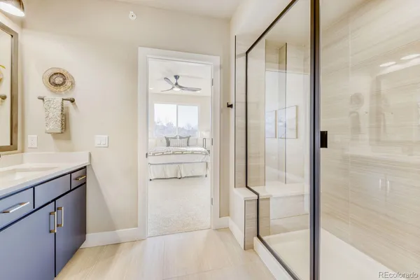 a bathroom with a tub shower sink and mirror