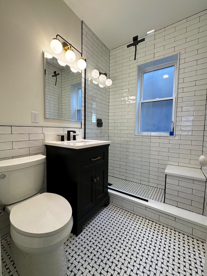 3078 North Davlin Court, Unit 2 Chicago, IL 60618 - Photo 11 of 19 a bathroom with a sink a toilet a mirror and vanity