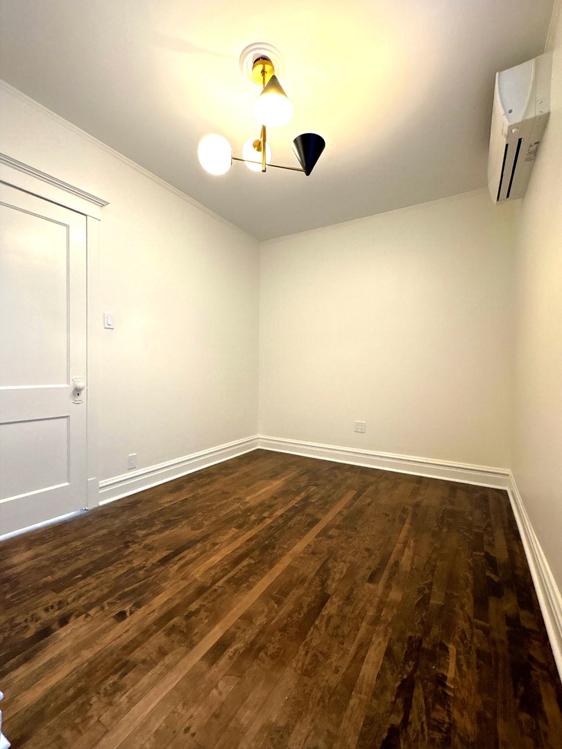 3078 North Davlin Court, Unit 2 Chicago, IL 60618 - Photo 13 of 19 an empty room with wooden floor and windows