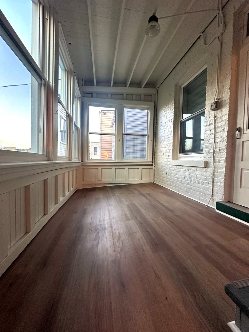 3078 North Davlin Court, Unit 2 Chicago, IL 60618 - Photo 16 of 19 an empty room with wooden floor and windows