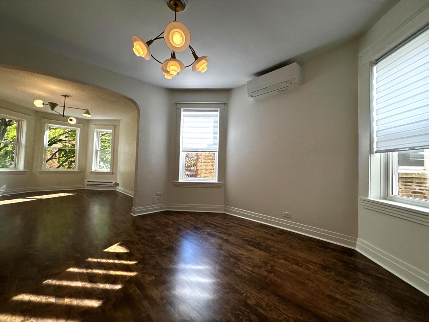 3078 North Davlin Court, Unit 2 Chicago, IL 60618 - Photo 4 of 19 an empty room with wooden floor and windows