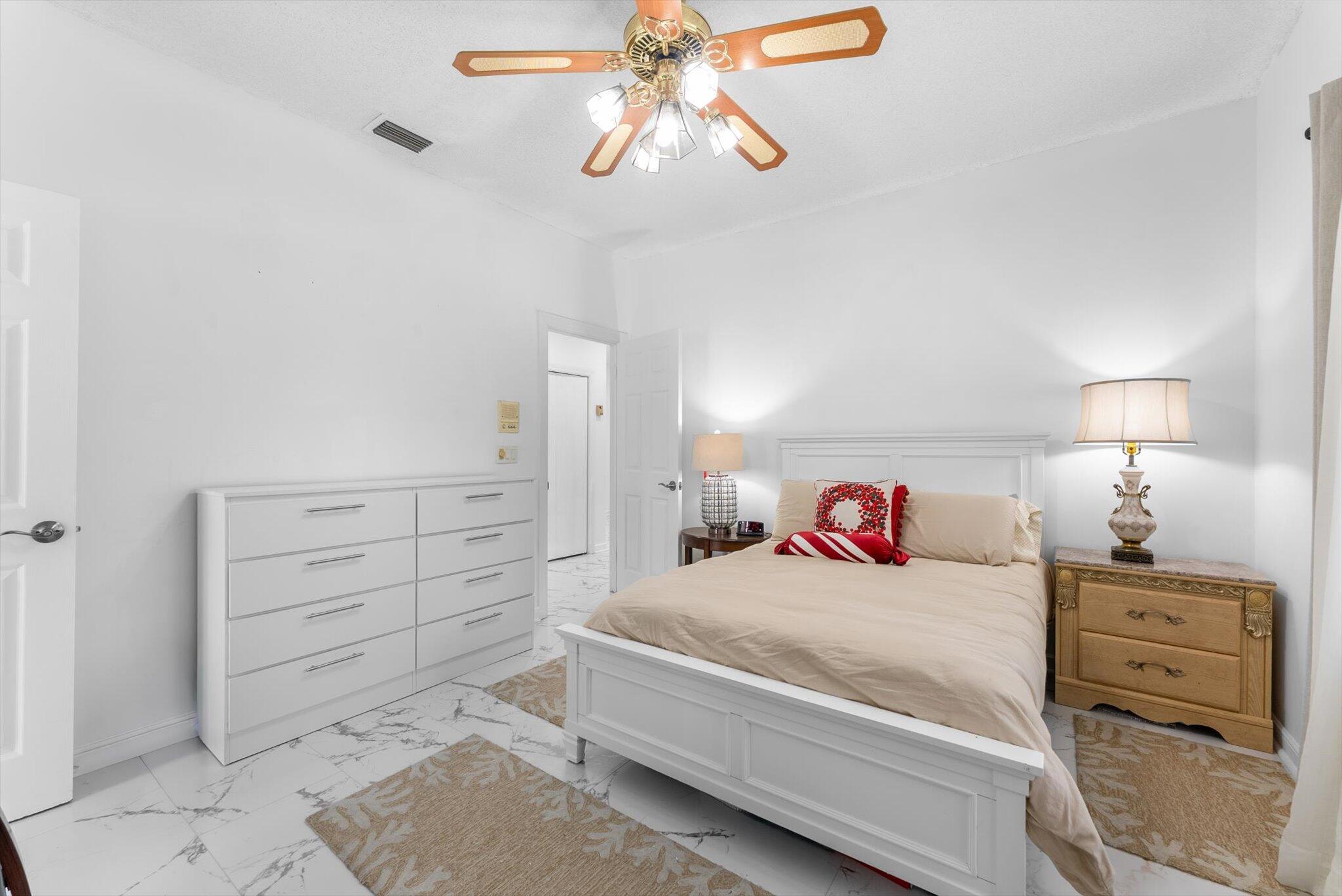 10722 Kirkaldy Lane Boca Raton, FL 33498 - Photo 30 of 76 a bedroom with a bed and a chandelier