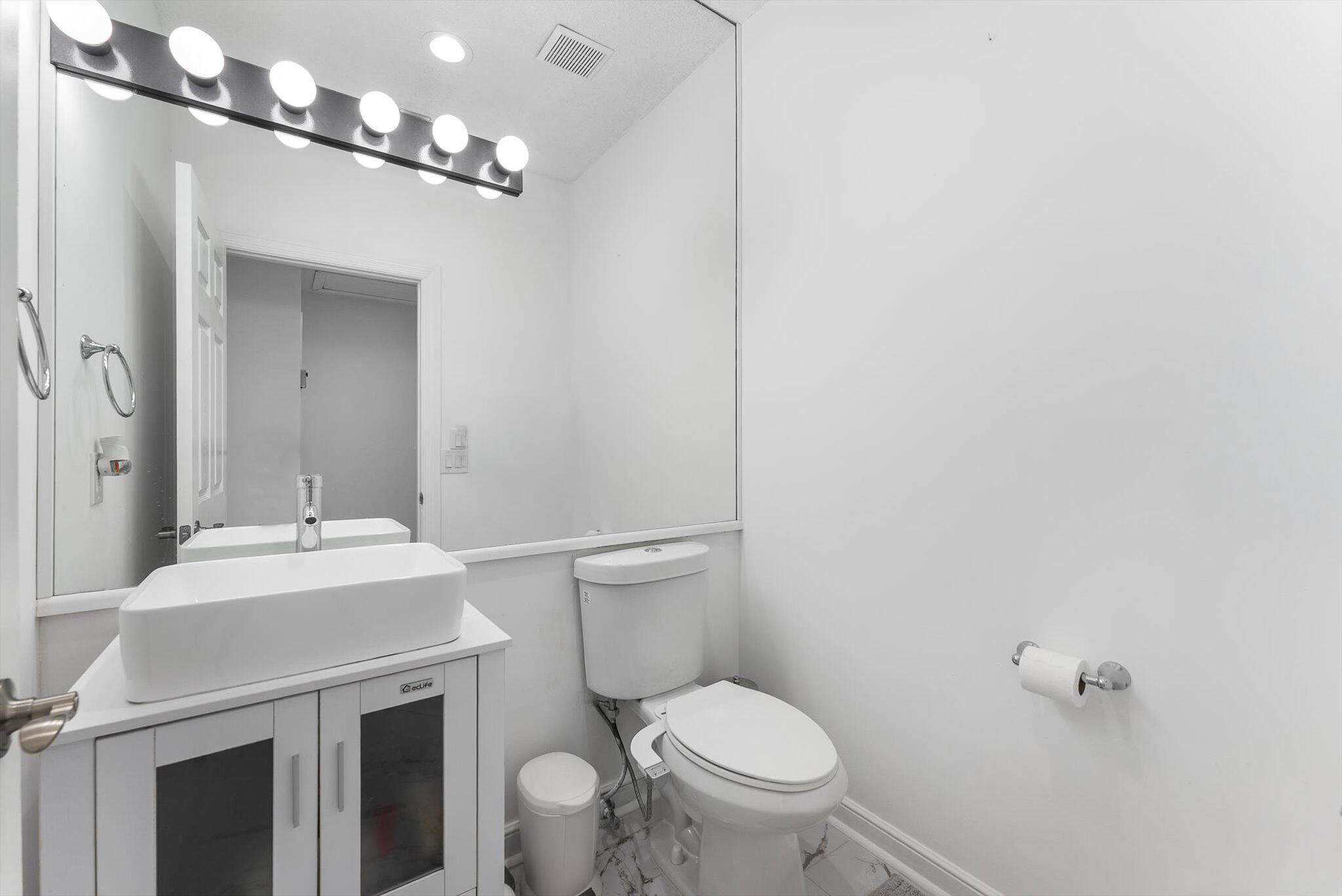 10722 Kirkaldy Lane Boca Raton, FL 33498 - Photo 31 of 76 a bathroom with a sink vanity mirror and toilet