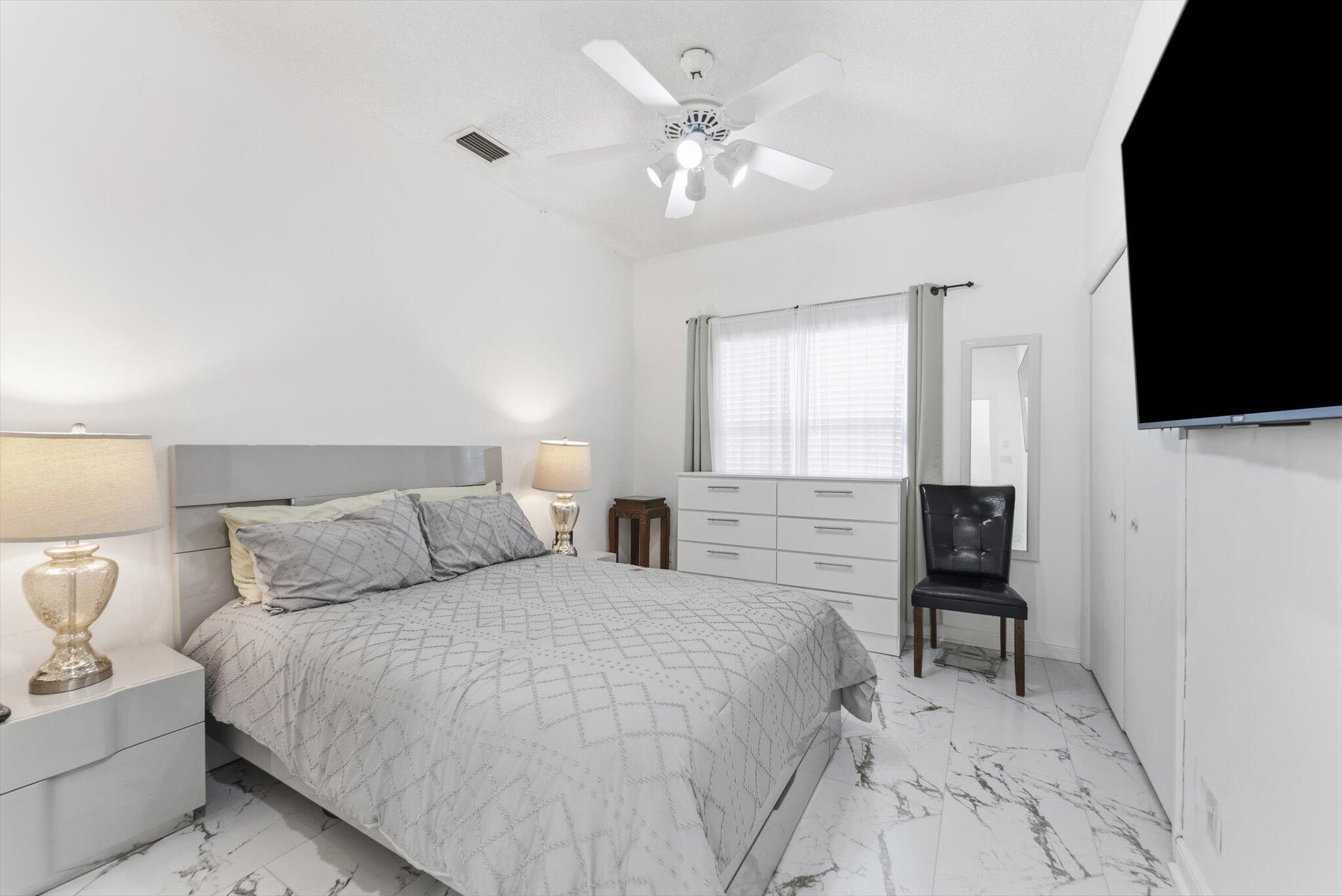 10722 Kirkaldy Lane Boca Raton, FL 33498 - Photo 34 of 76 a bedroom with a bed and a flat screen tv