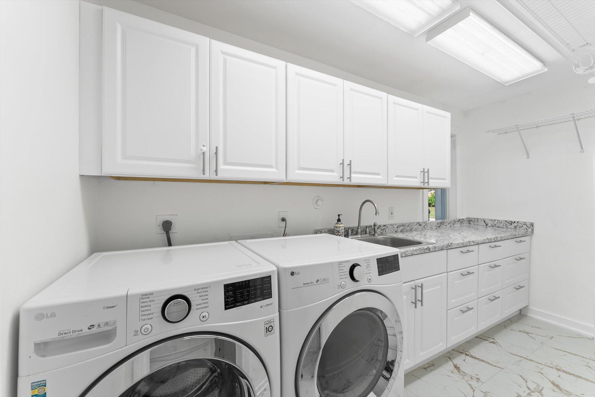 10722 Kirkaldy Lane Boca Raton, FL 33498 - Photo 36 of 76 a view of washer and dryer with kitchen in the background