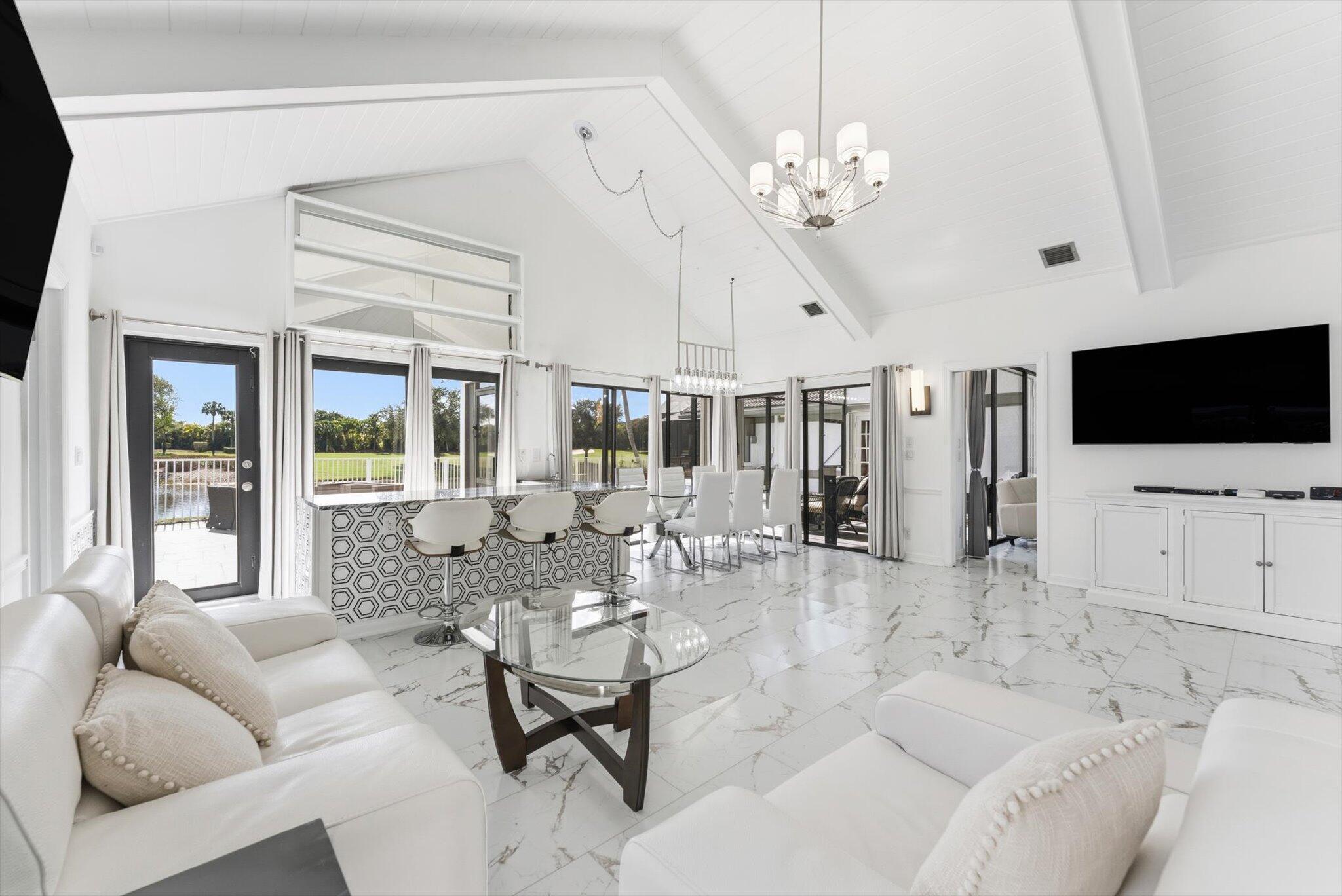 10722 Kirkaldy Lane Boca Raton, FL 33498 - Photo 6 of 76 a living room with furniture a flat screen tv and a chandelier