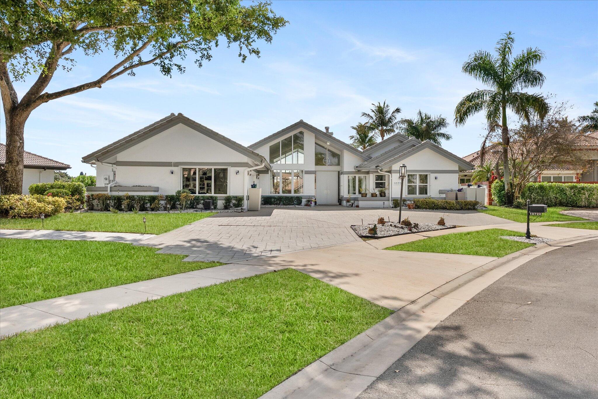 10722 Kirkaldy Lane Boca Raton, FL 33498 - Photo 73 of 76 a front view of a house with a garden and trees