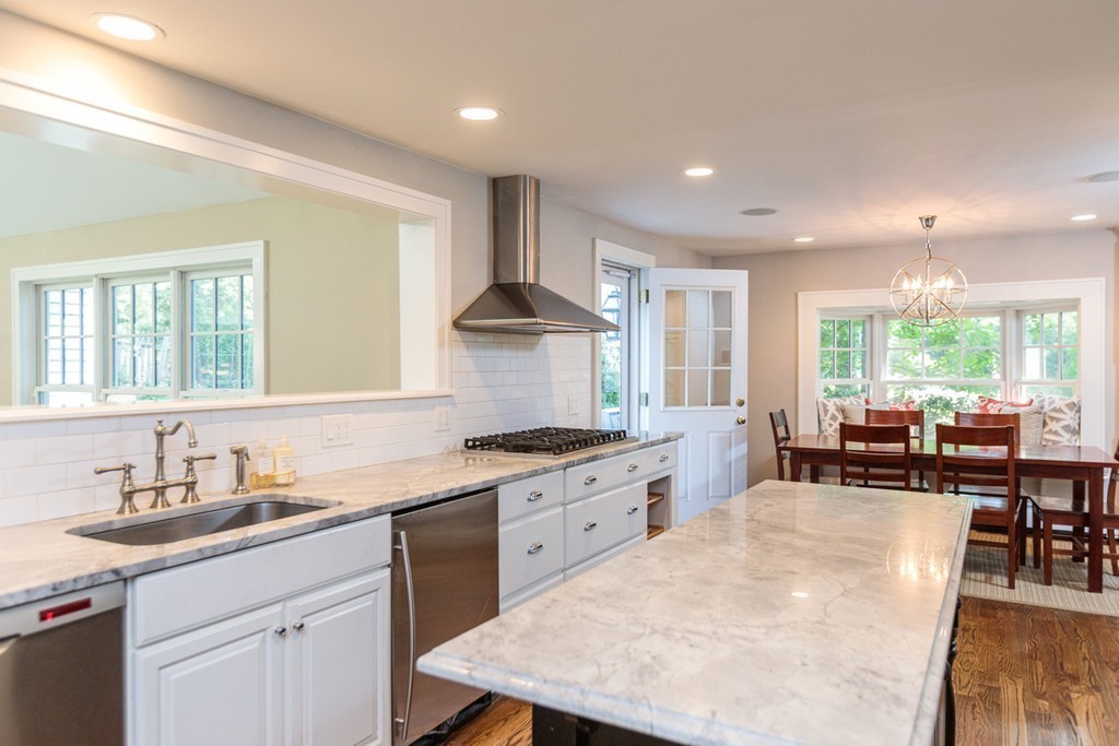 69 Fox Hill Road Wellesley, MA 02481 - Photo 7 of 30 a kitchen with stainless steel appliances granite countertop a stove a sink a oven a dining table and chairs with wooden floor