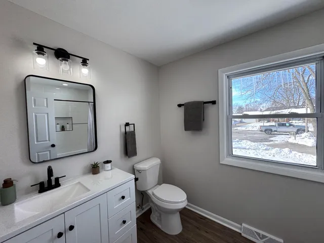 a bathroom with a toilet sink and mirror