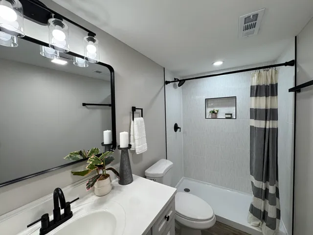 a bathroom with a sink toilet and shower
