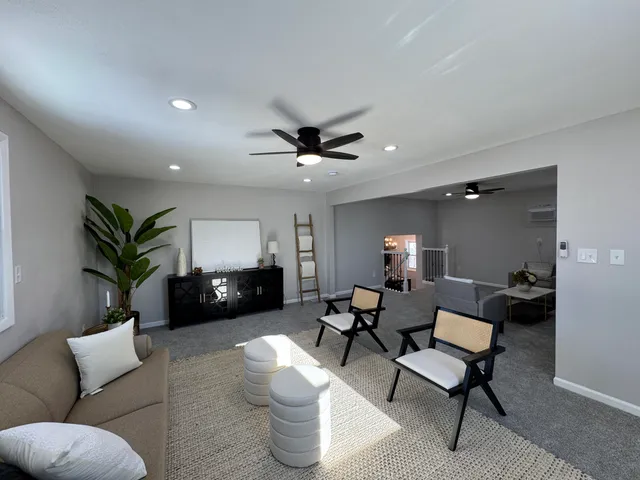 a living room with furniture and a ceiling fan