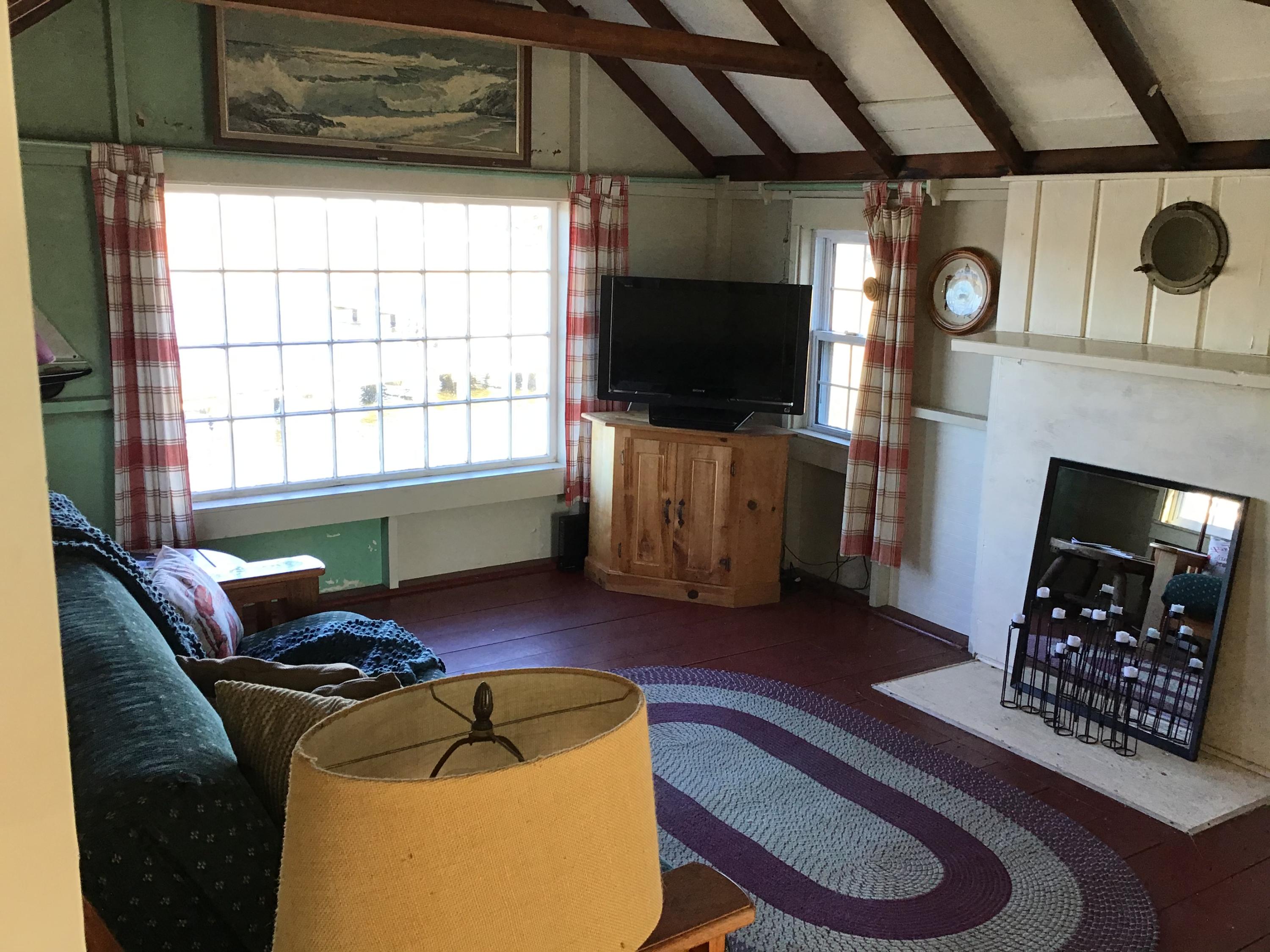 10 Lower County Road Dennis Port, MA 02639 - Photo 13 of 25 a living room with furniture a flat screen tv and a fireplace