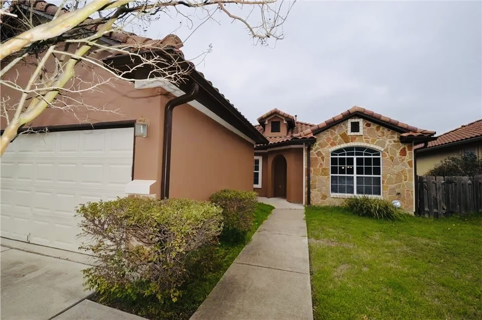 5624 Toscana Avenue Austin, TX 78724 - Photo 1 of 31 Mediterranean / spanish home featuring stone siding, stucco siding, an attached garage, driveway, and a tile roof