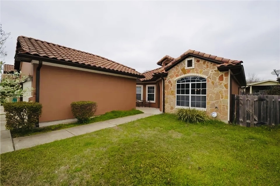 5624 Toscana Avenue Austin, TX 78724 - Photo 2 of 31 Back of property featuring a tiled roof, stone siding, and stucco siding
