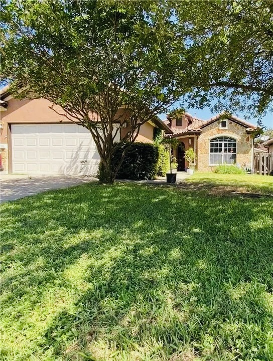 5624 Toscana Avenue Austin, TX 78724 - Photo 4 of 31 View of front of home with concrete driveway, a front yard, stucco siding, a garage, and stone siding