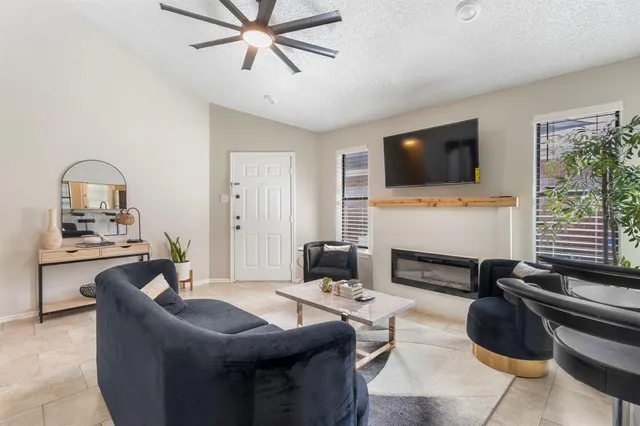 a living room with furniture a flat screen tv and a fireplace