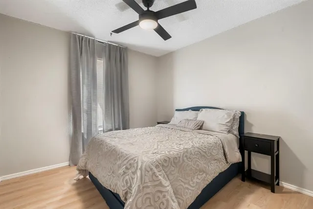 a bedroom with a bed and a ceiling fan