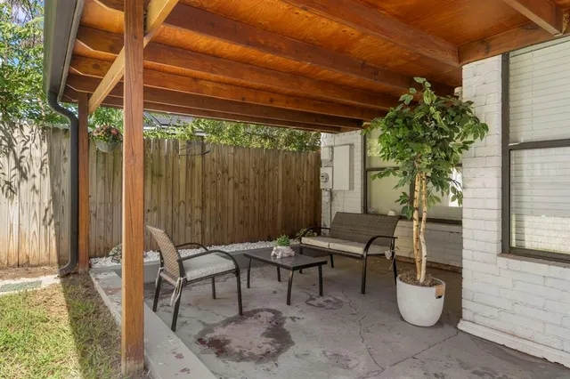 a porch with a table and chairs and potted plants
