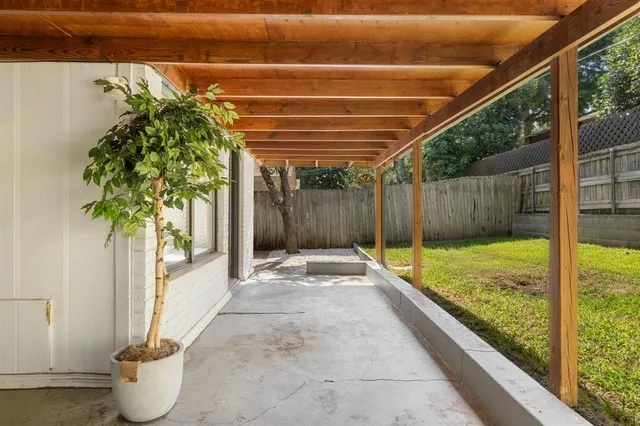 a view of a patio with table and chairs under an umbrella