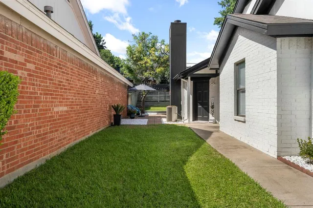 a view of a house with backyard and a tree