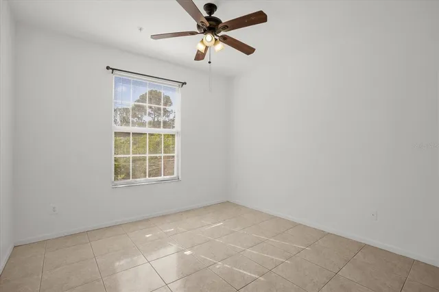 an empty room with windows and fan