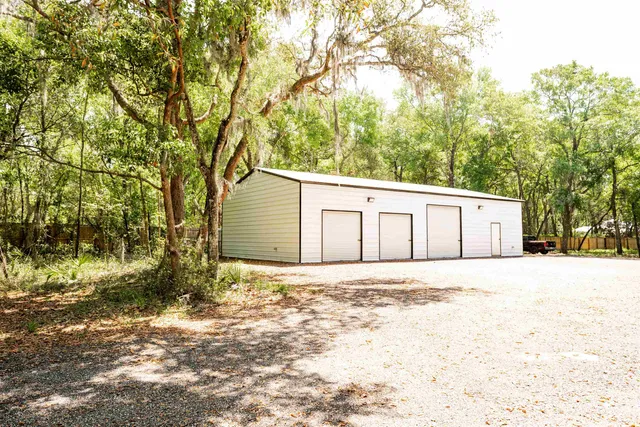 a white house that has tree in front of it