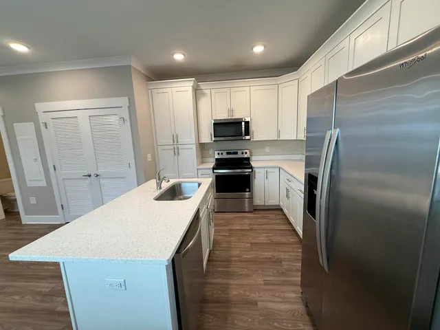 a kitchen with kitchen island a refrigerator sink and stove
