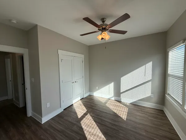 a view of empty room with wooden floor and window