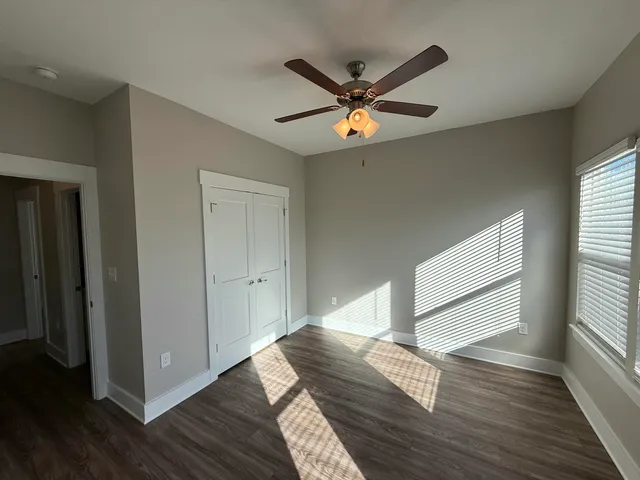 a view of empty room with wooden floor and window