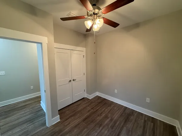 a view of an empty room with wooden floor
