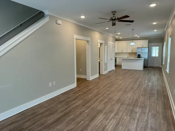 a view of a big room with wooden floor and a kitchen