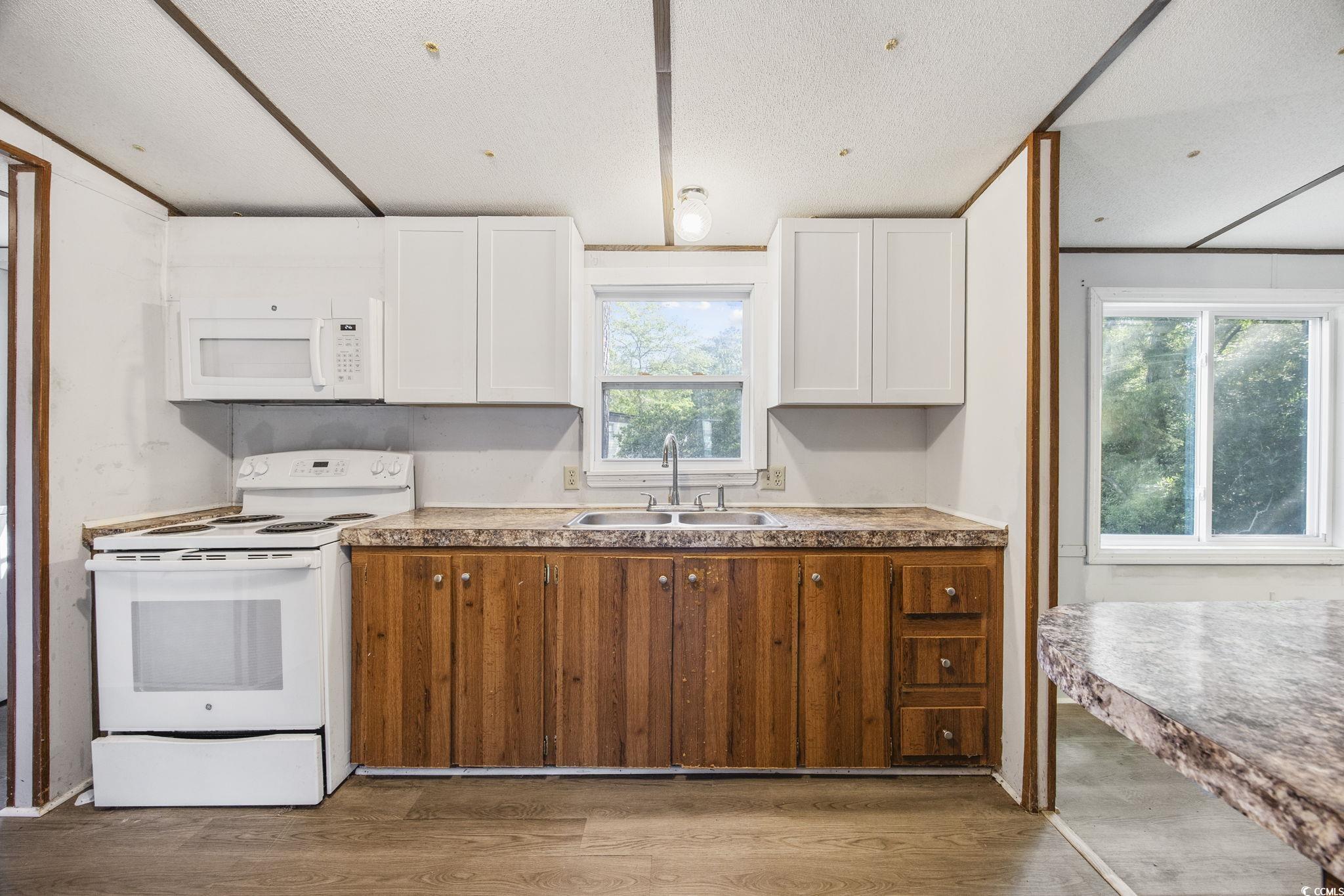 167 Offshore Drive Murrells Inlet, SC 29576 - Photo 11 of 33 Kitchen with white appliances, a sink, wood finish