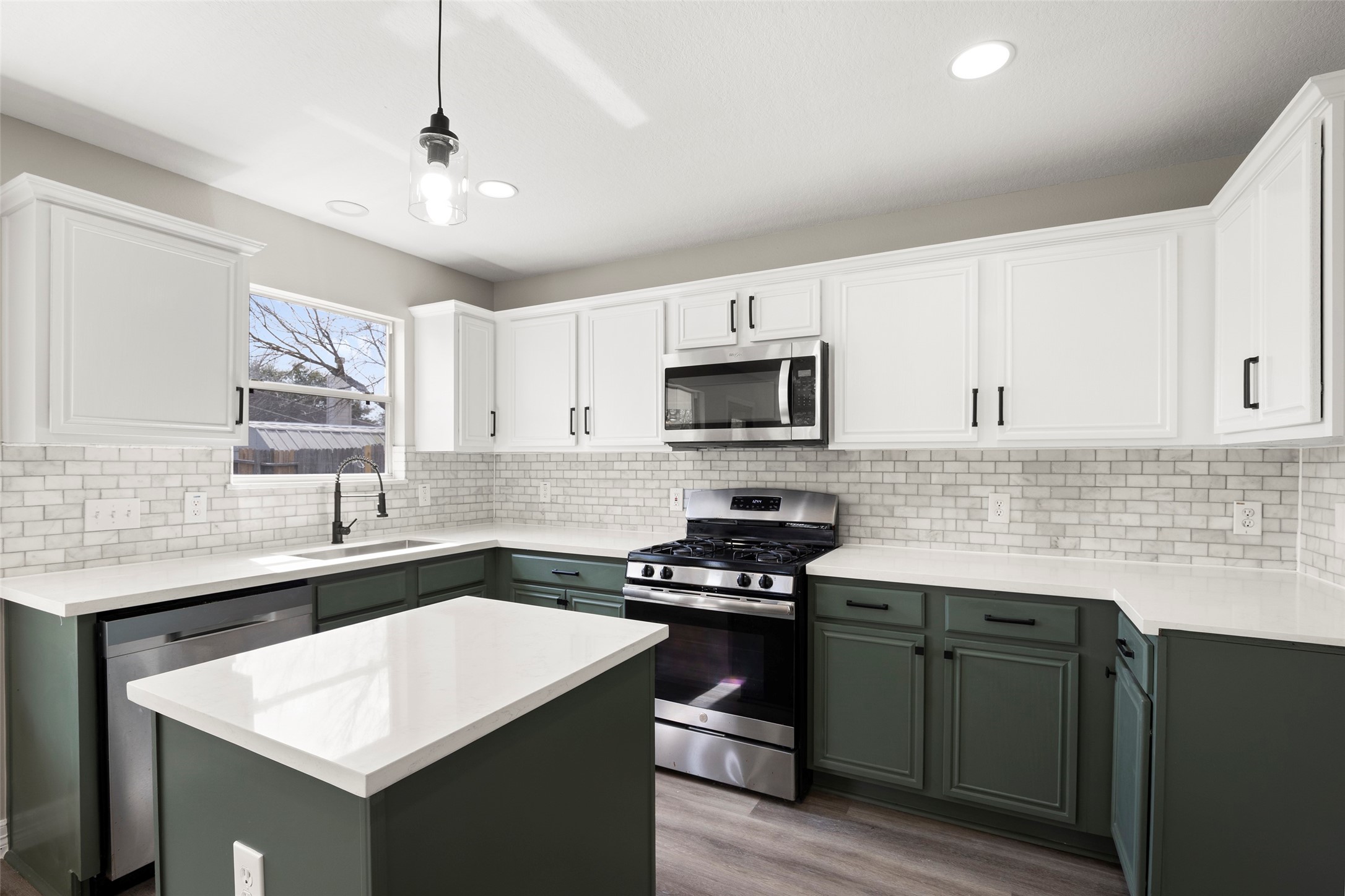 a kitchen with granite countertop a sink a stove cabinets and wooden floor