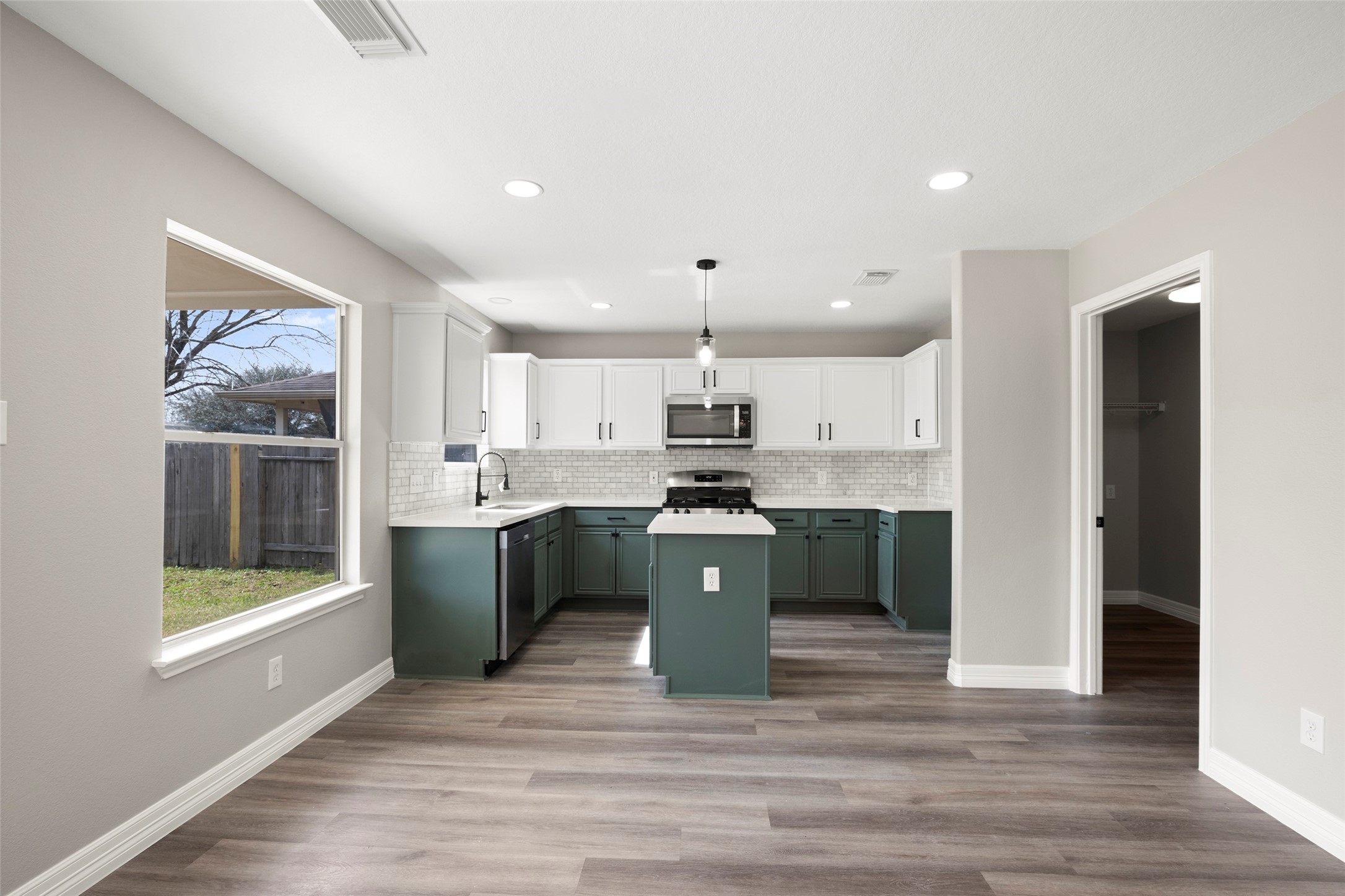 2406 Pinpoint Drive Spring, TX 77373 - Photo 12 of 25 a large kitchen with kitchen island a sink a stove a refrigerator and a cabinets