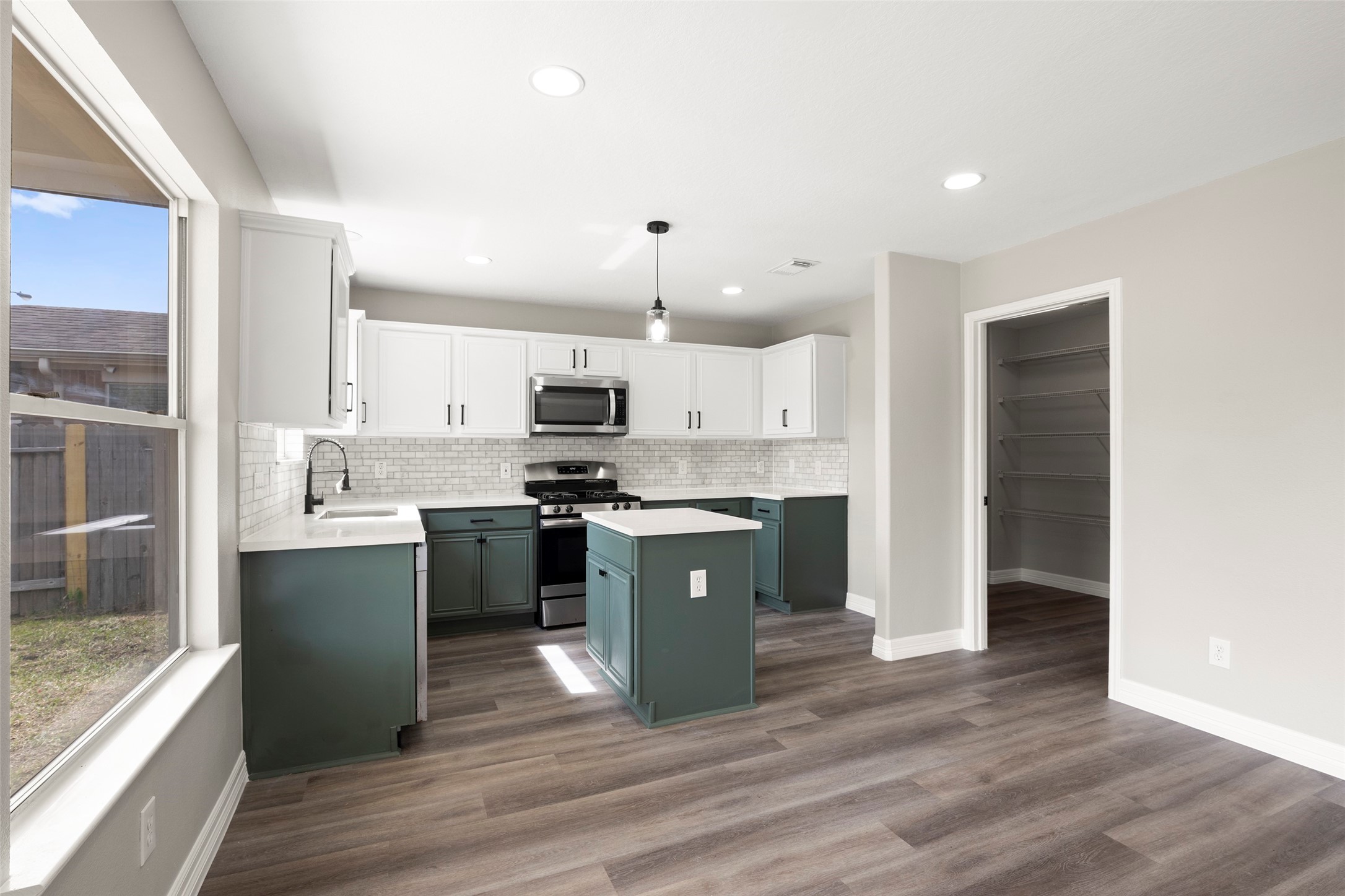 2406 Pinpoint Drive Spring, TX 77373 - Photo 13 of 25 a large kitchen with stainless steel appliances kitchen island granite countertop a refrigerator a sink a stove and white cabinets with wooden floor