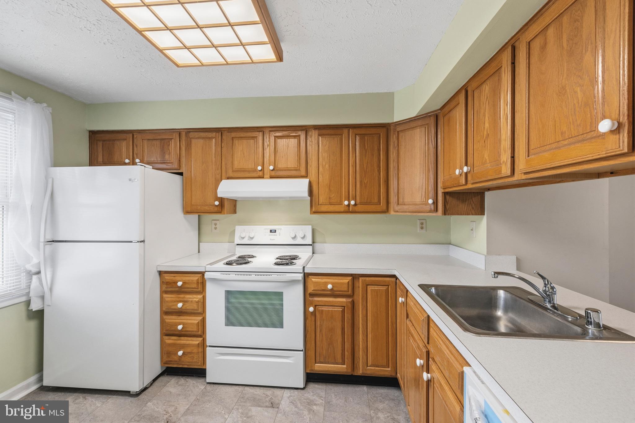 232 Canfield Terrace Frederick, MD 21702 - Photo 4 of 30 a kitchen with a sink stove and refrigerator