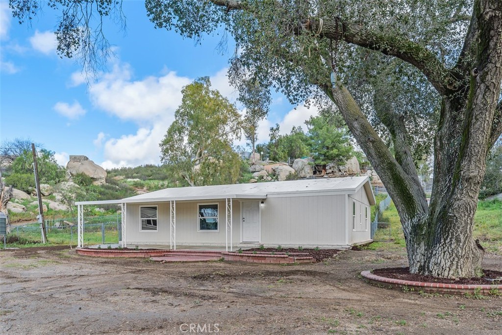 42580 East Benton Road Hemet, CA 92544 - Photo 6 of 31 a view of a house with a tree and a yard