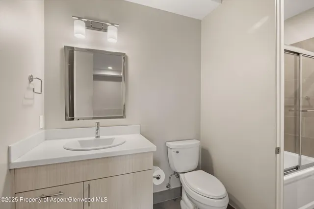 a bathroom with a sink toilet and mirror