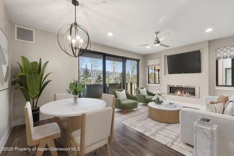 a living room with furniture a chandelier and a flat screen tv
