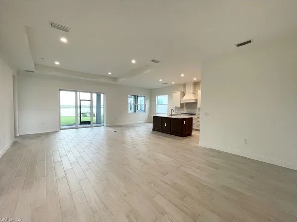 a view of empty room with kitchen view