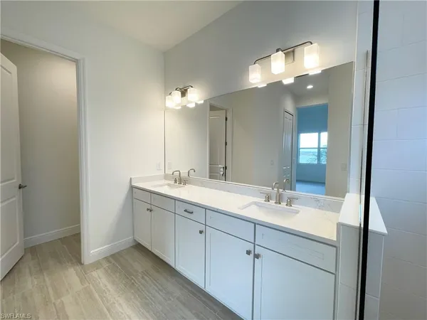 a bathroom with a double vanity sink and a mirror
