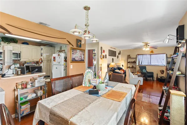 a view of a dining room and livingroom with furniture wooden floor a chandelier