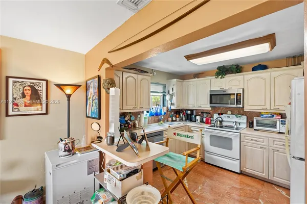 a room with stainless steel appliances a sink and a refrigerator