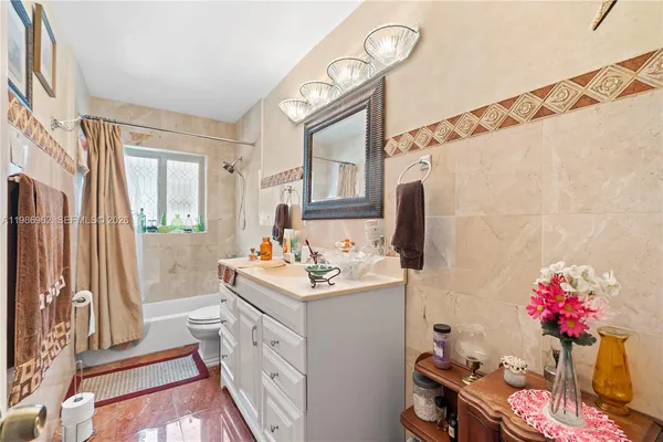 a bathroom with a sink vanity mirror and a bathtub