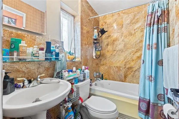 a bathroom with a sink and bathtub with toilet