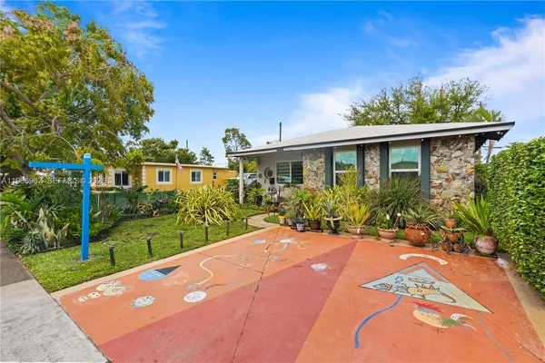 a view of a backyard with plants and large trees