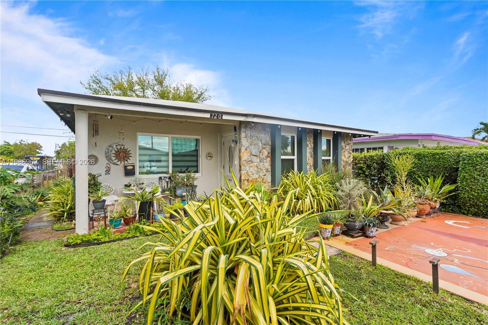 720 Northwest 4th Street Hallandale Beach, FL 33009 - Photo 4 of 27 a front view of a house with a yard