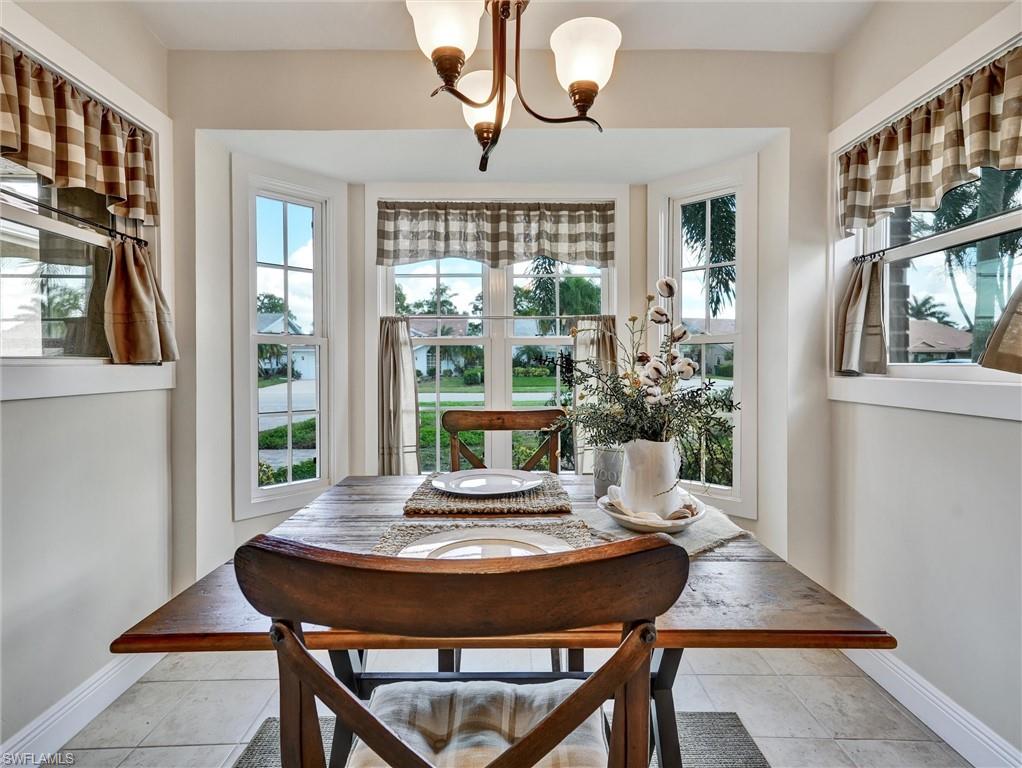 421 Countryside Drive Naples, FL 34104 - Photo 12 of 44 Dining space with a chandelier and light tile patterned floors