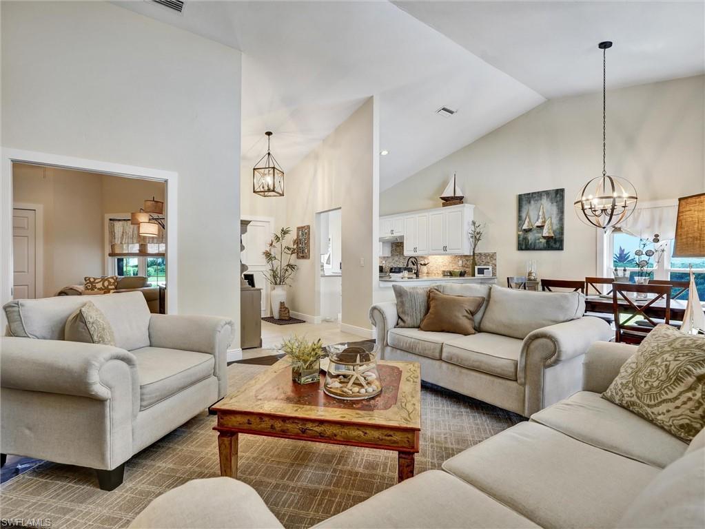 421 Countryside Drive Naples, FL 34104 - Photo 14 of 44 Living room featuring a chandelier and high vaulted ceiling