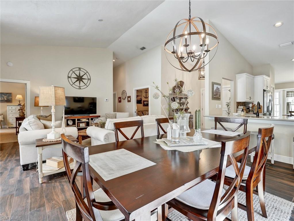 421 Countryside Drive Naples, FL 34104 - Photo 16 of 44 Dining room with dark wood-type flooring, high vaulted ceiling, a chandelier, and recessed lighting